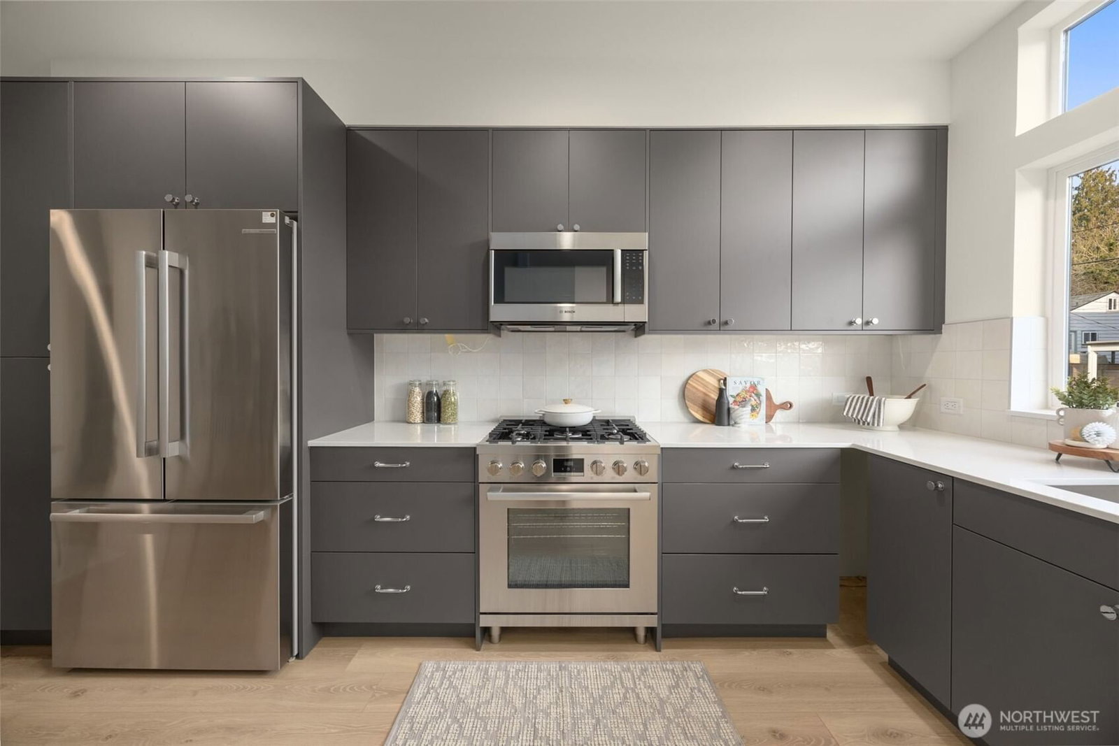 Kitchen with charcoal cabinetry and a window over the sink