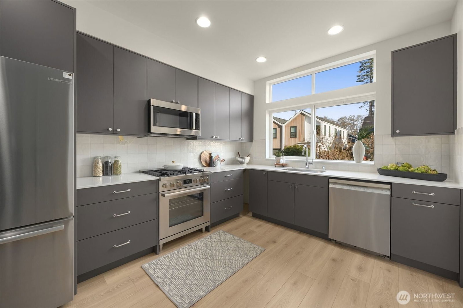 Kitchen with quartz counters, stainless appliances and gas cooking