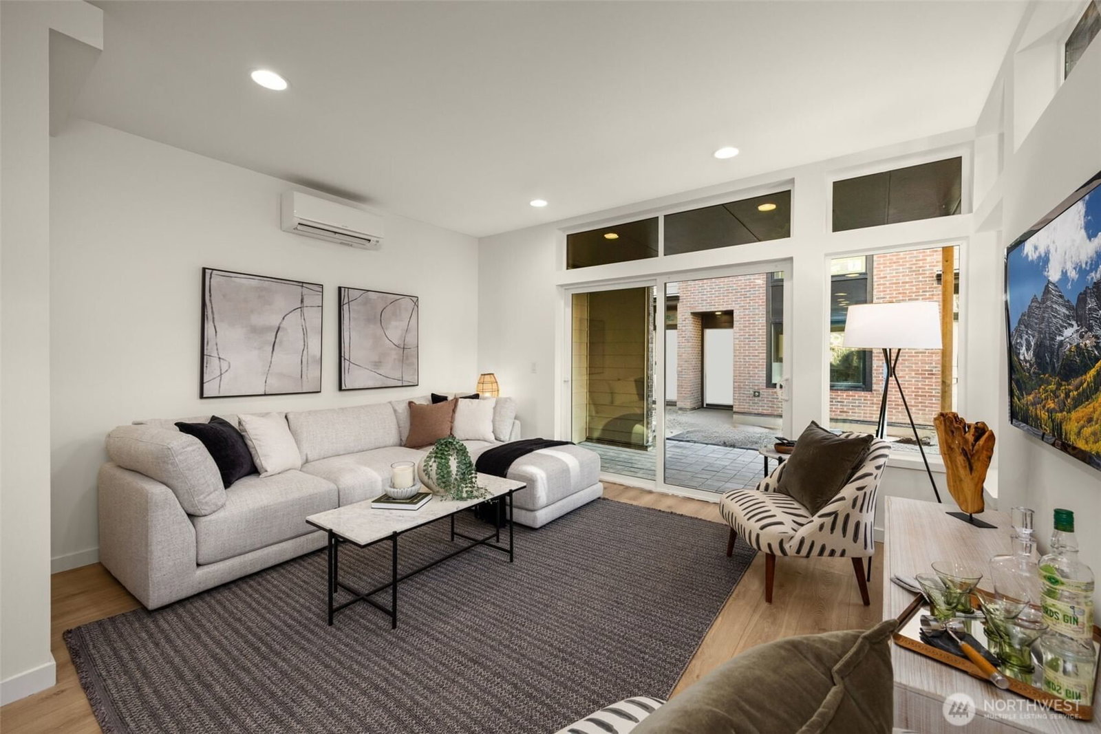 Second-floor living room with a wall of windows to the courtyard